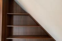 Regal aus dunklem Holzfurnier angepasst an Dachschräge