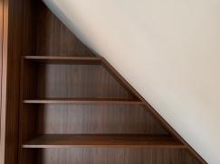 Regal aus dunklem Holzfurnier angepasst an Dachschräge