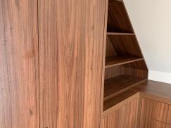 Regal aus dunklem Holzfurnier angepasst an Dachschräge