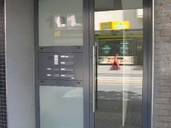 Glas-Haustür mit grauem Rahmen und Seitenteil mit Briefkastenanlage