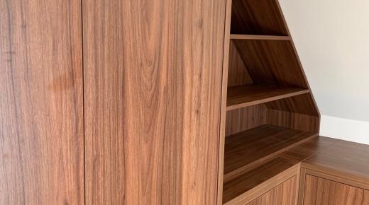 Regal aus dunklem Holzfurnier angepasst an Dachschräge