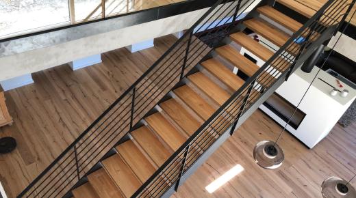Stahltreppe schwarz mit Holzbelag als Aufgang zu Galerie