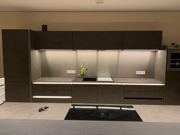 Großzügige Küchenzeile grau mit atmosphärischer LED-Beleuchtung