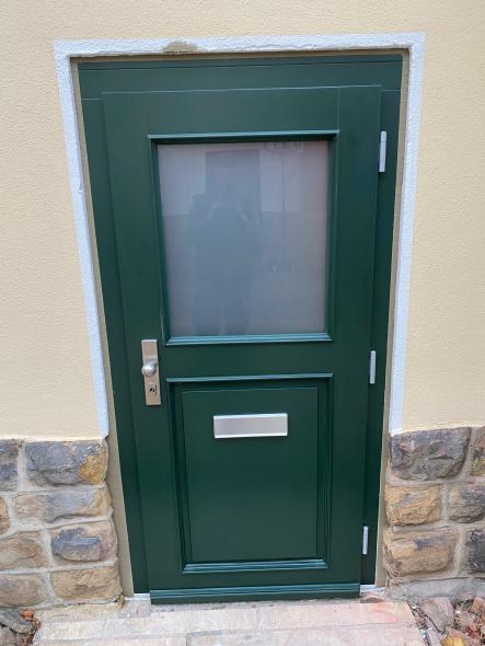 Grüne Holzhaustür mit halbseitigem Lichtausschnitt Außenansicht