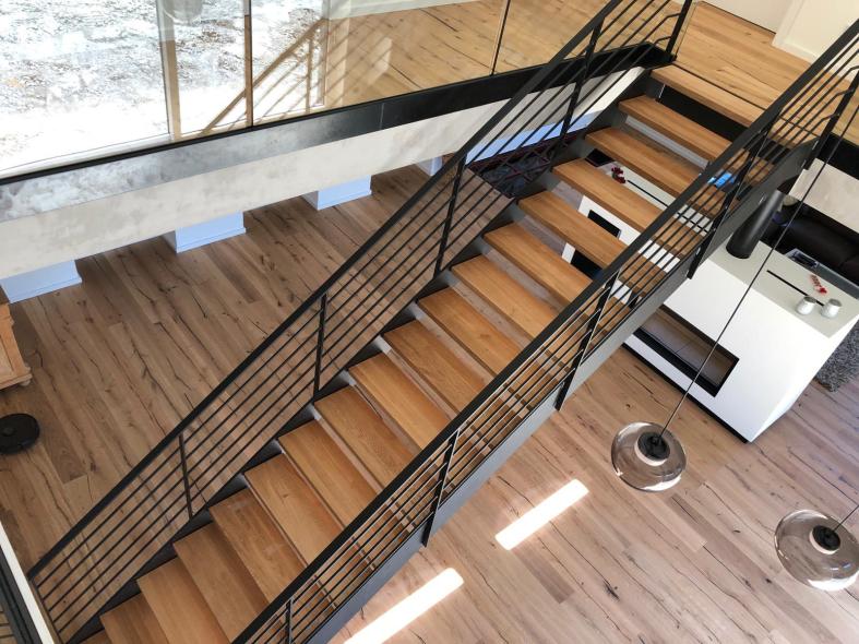 Stahltreppe schwarz mit Holzbelag als Aufgang zu Galerie