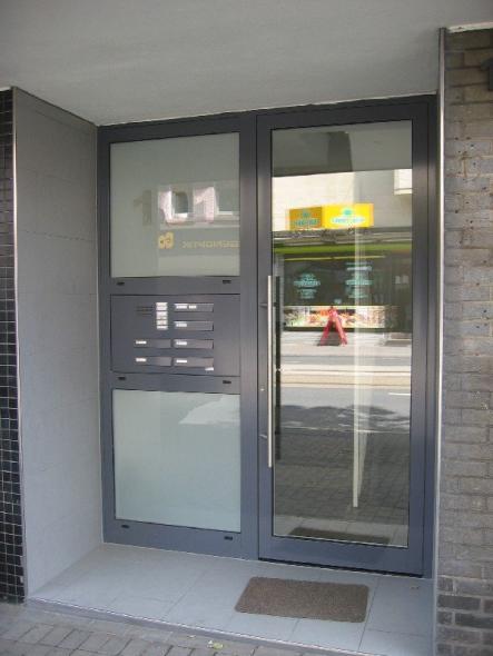 Glas-Haustür mit grauem Rahmen und Seitenteil mit Briefkastenanlage 
