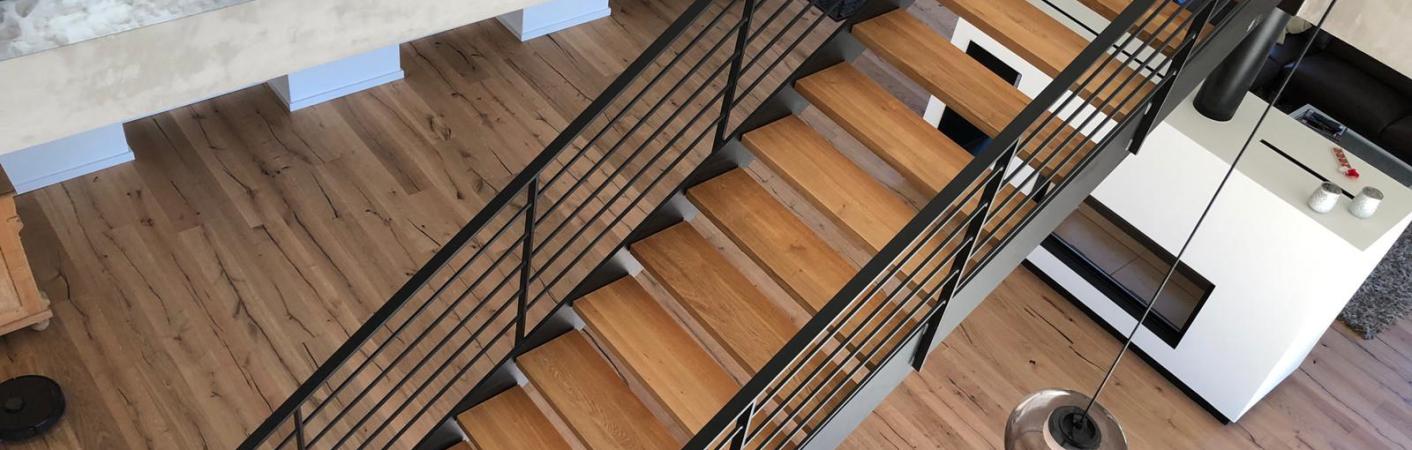 Stahltreppe schwarz mit Holzbelag als Aufgang zu Galerie